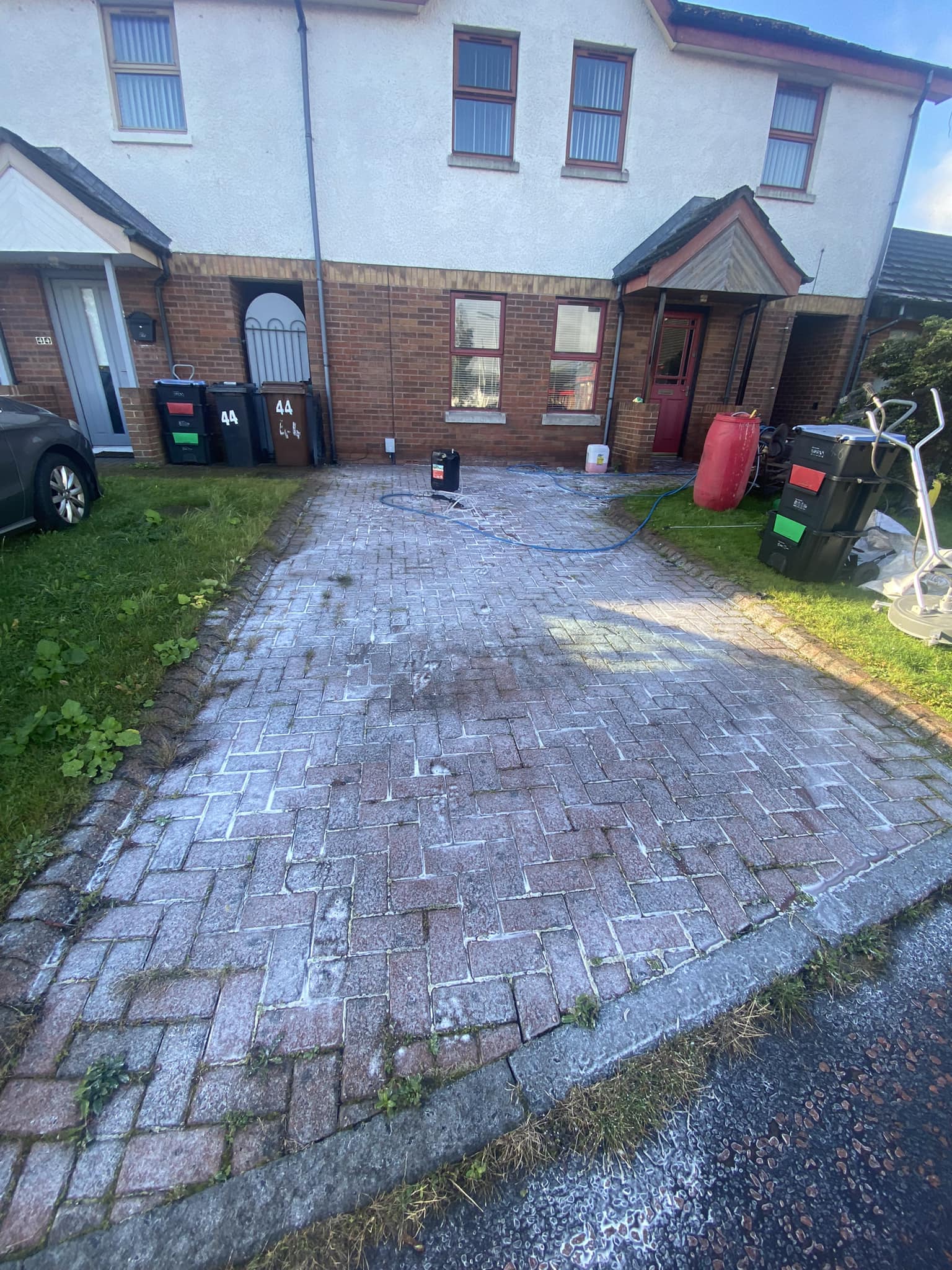 driveway covered in cleaning solution foam before powerwashing
