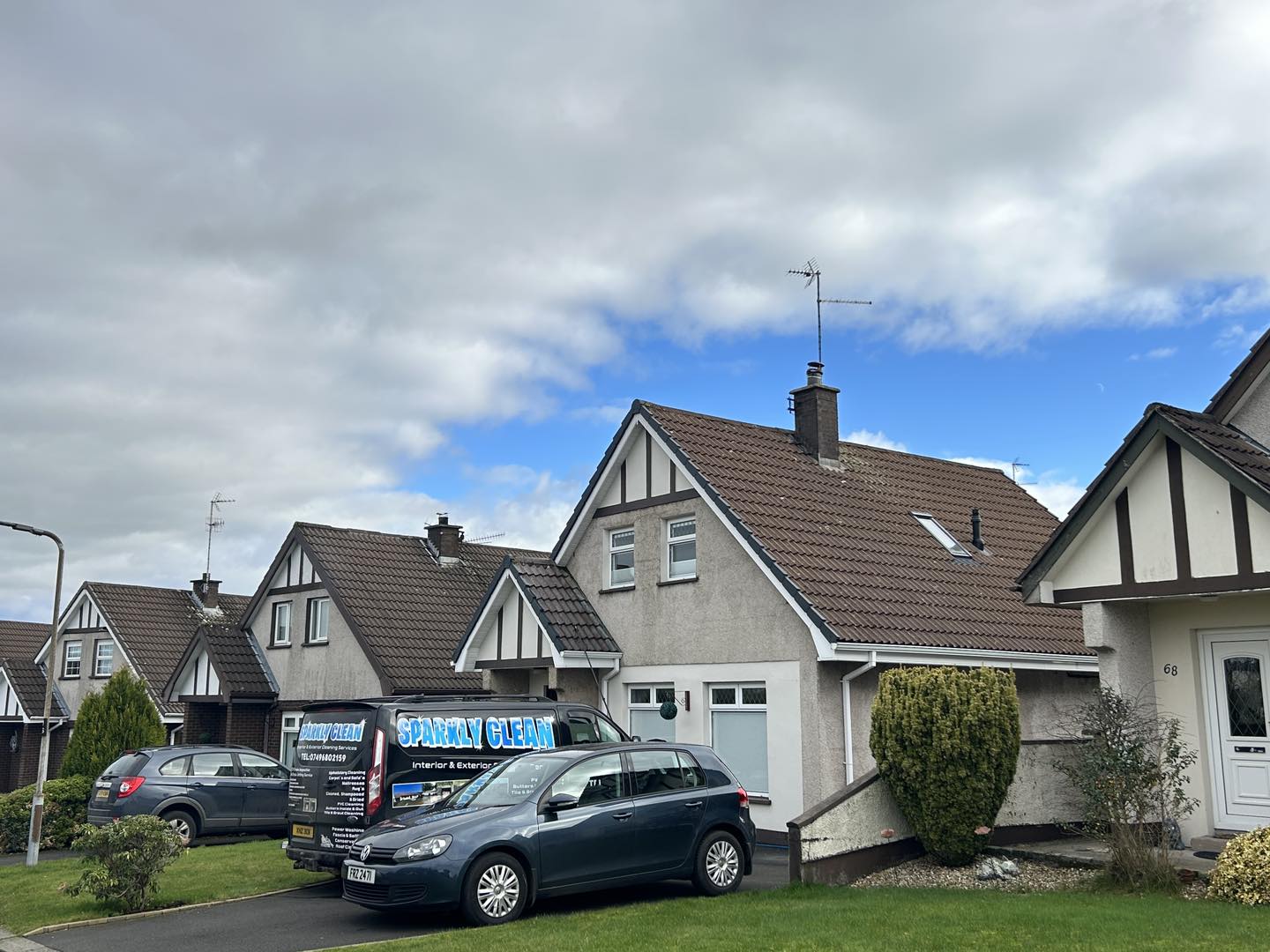 Sparkly clean van in front of newly washed house roof and render walls
