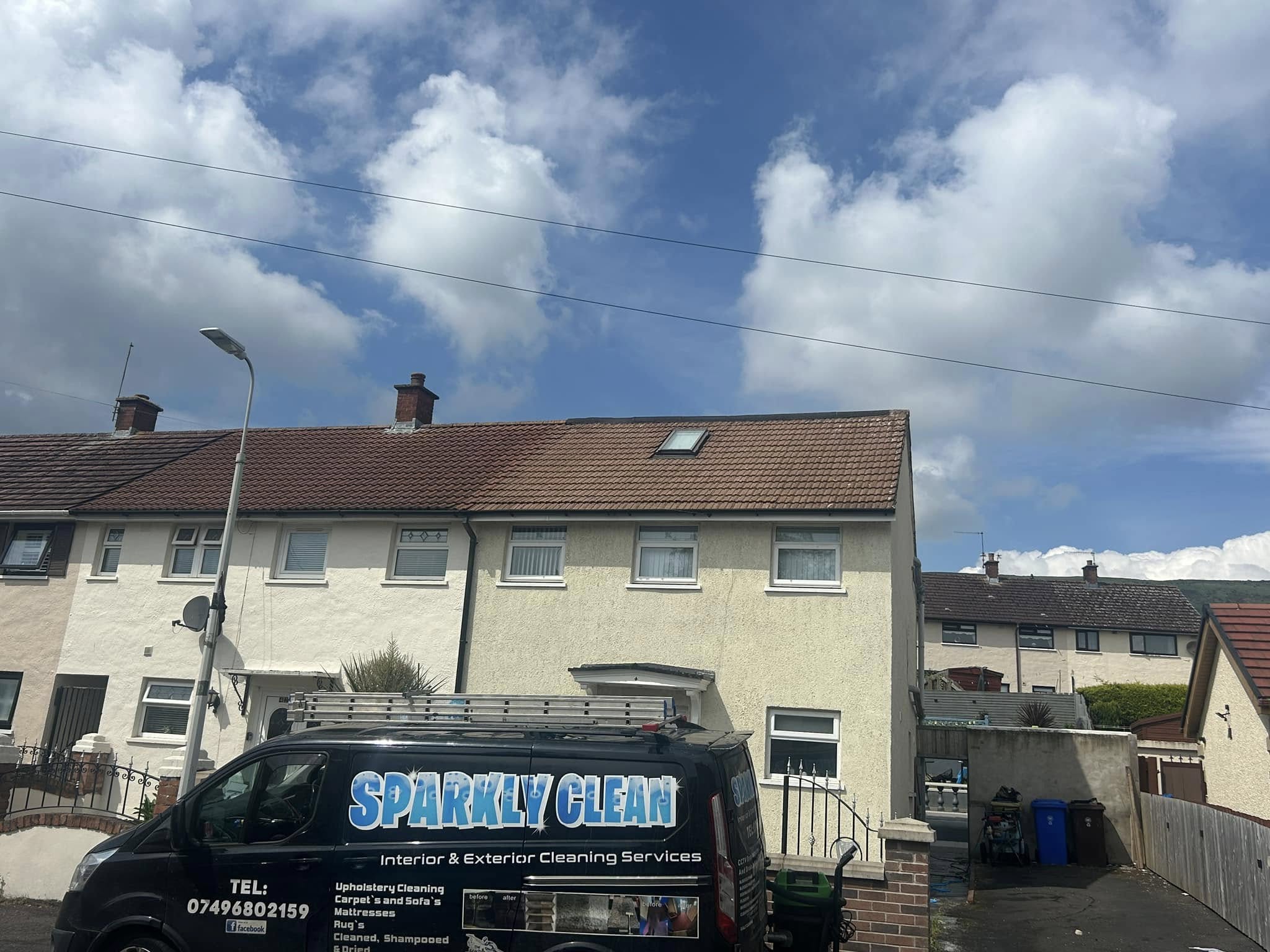 Sparkly clean van in front of newly washed house roof and render walls